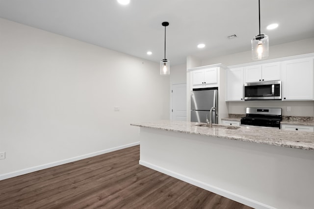 kitchen with hanging light fixtures, appliances with stainless steel finishes, dark hardwood / wood-style floors, and white cabinets