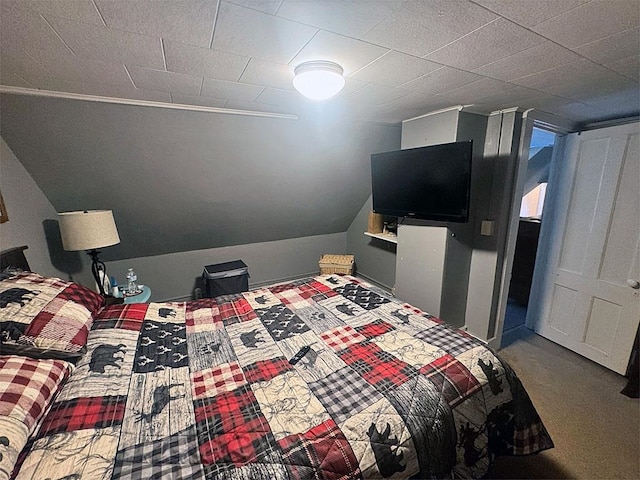 bedroom featuring lofted ceiling and carpet