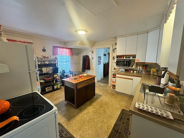 kitchen with white appliances, white cabinets, and sink