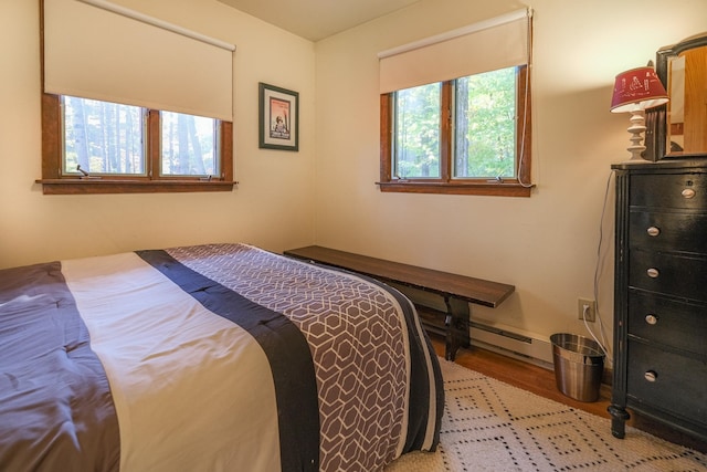 bedroom with baseboard heating and light wood-type flooring