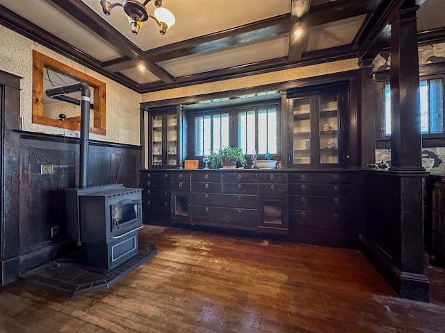 office space with beamed ceiling, coffered ceiling, a wood stove, and dark hardwood / wood-style flooring