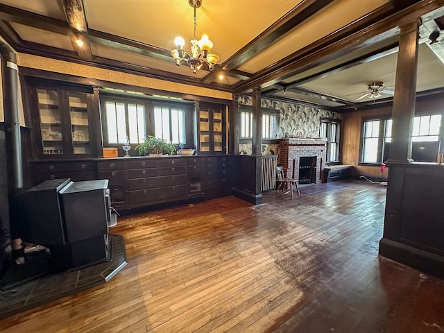 interior space featuring a fireplace, hardwood / wood-style floors, beam ceiling, and ceiling fan with notable chandelier