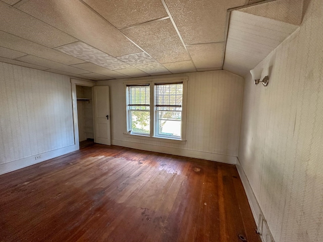 empty room with lofted ceiling and dark wood-type flooring