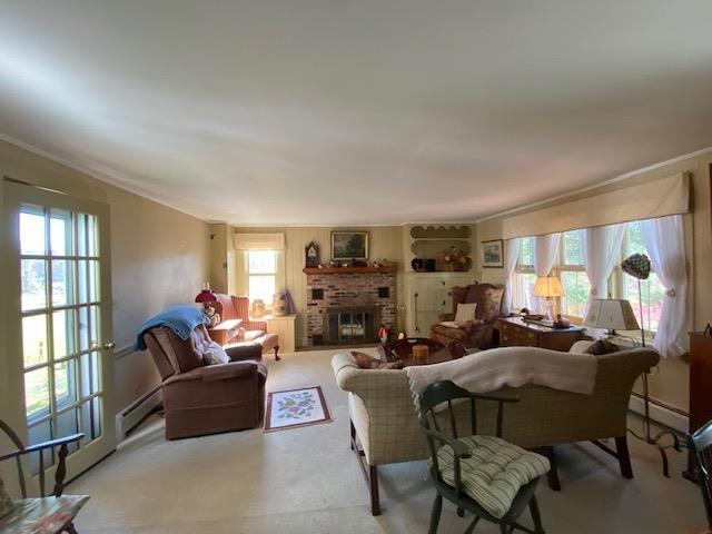 44 Pleasant View Rd, Bradford, NH 03221 - living room featuring a baseboard heating unit, healthy amount of natural light, and a brick fireplace
