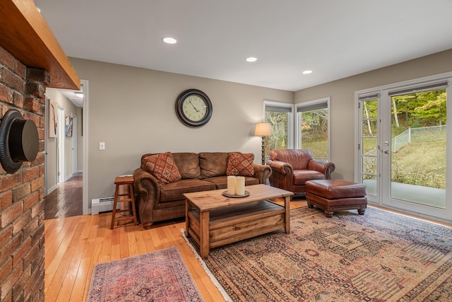 living room with light hardwood / wood-style floors and a baseboard heating unit