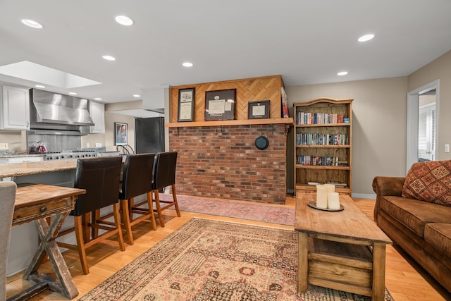 living room with light hardwood / wood-style floors and a skylight