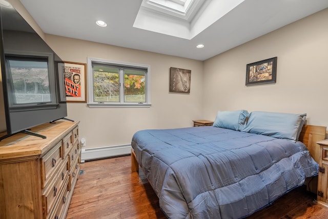 bedroom with a skylight, a baseboard radiator, and dark hardwood / wood-style flooring