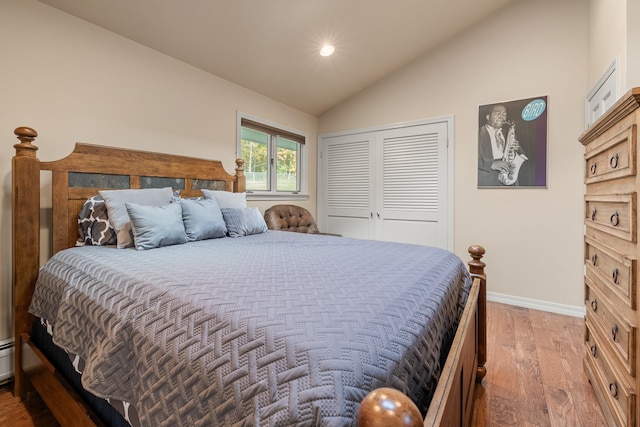 bedroom with vaulted ceiling, hardwood / wood-style flooring, and a closet