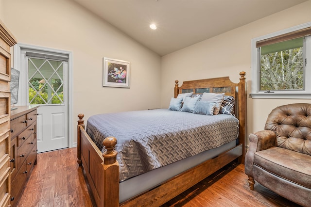 bedroom with vaulted ceiling and hardwood / wood-style floors