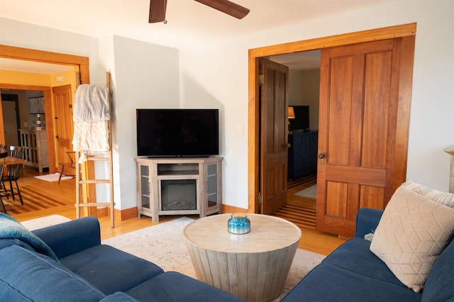 living room featuring light hardwood / wood-style flooring and ceiling fan