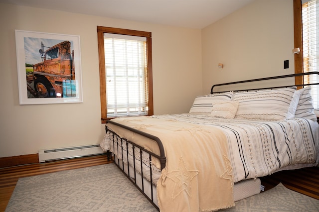 bedroom with light hardwood / wood-style flooring and a baseboard radiator