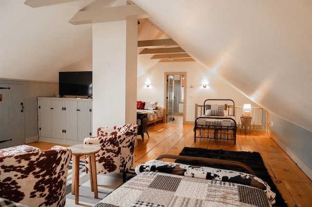 bedroom with light hardwood / wood-style flooring and vaulted ceiling with beams