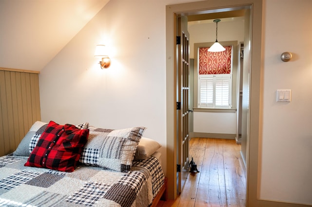 bedroom with light hardwood / wood-style floors and vaulted ceiling