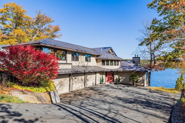 20 Bonardi Dr, Enfield, NH 03748 - view of front of property featuring a chimney, driveway, a standing seam roof, metal roof, and a garage
