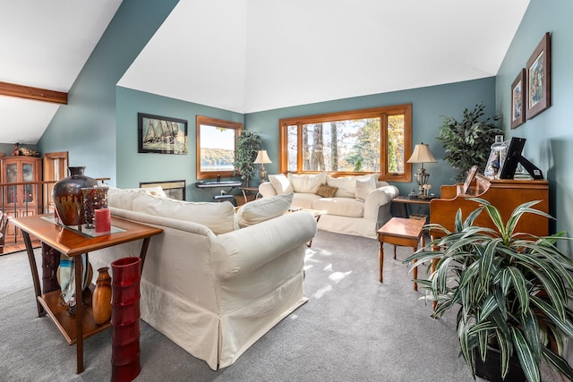 carpeted living room featuring vaulted ceiling with beams