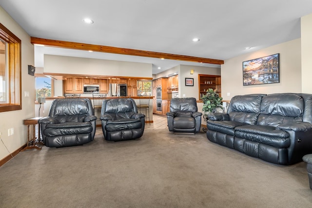 living room with beam ceiling and light carpet