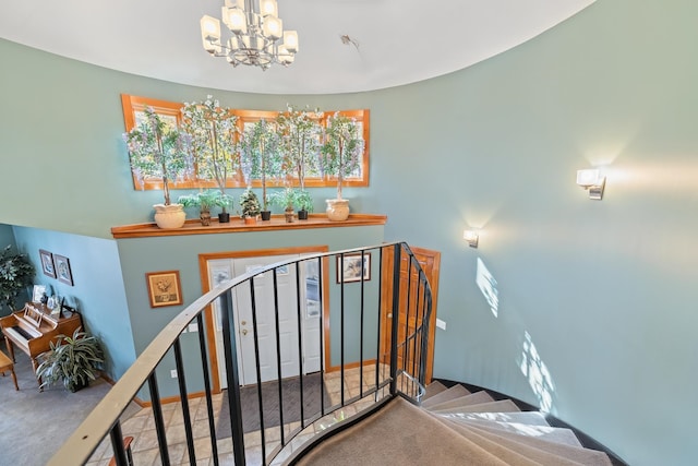 stairs featuring carpet flooring and a chandelier