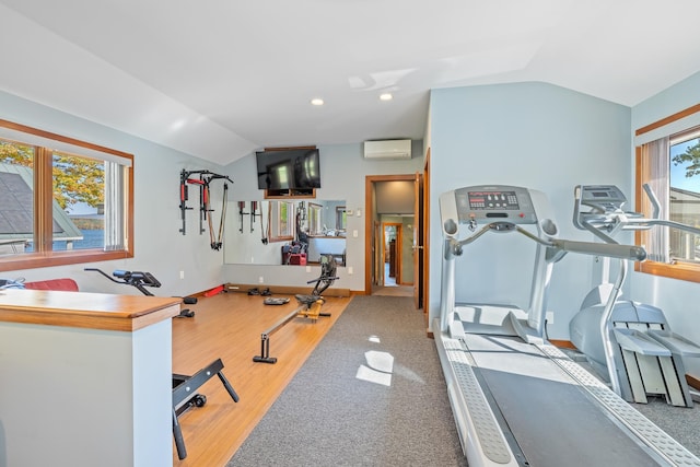 exercise area featuring a wall unit AC, carpet, and vaulted ceiling