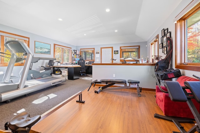 workout area featuring vaulted ceiling and light hardwood / wood-style flooring