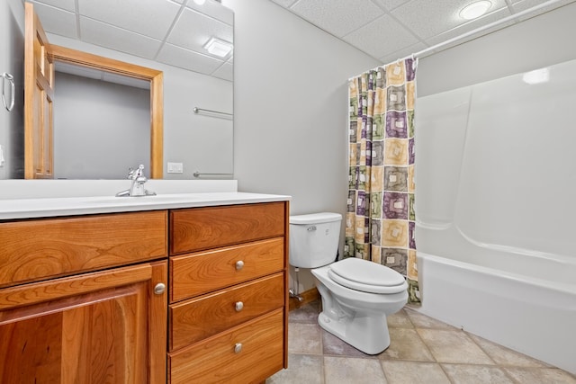 full bathroom featuring a drop ceiling, vanity, tile patterned floors, shower / bath combination with curtain, and toilet