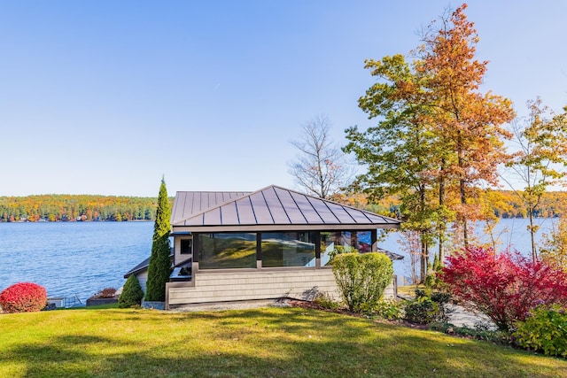 view of dock featuring a lawn and a water view