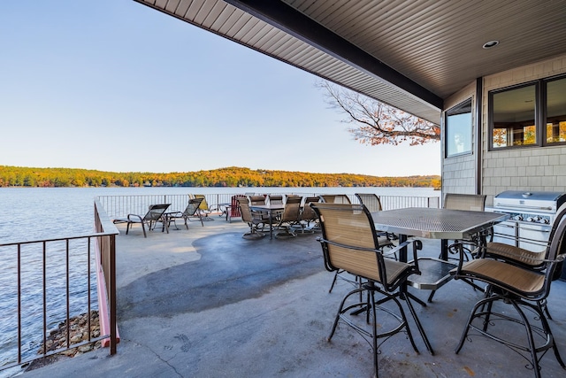 view of patio featuring a water view and a grill