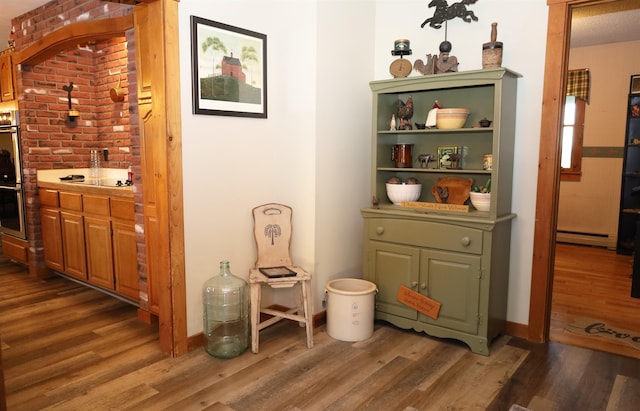 bar featuring a baseboard radiator, white gas cooktop, and dark hardwood / wood-style flooring