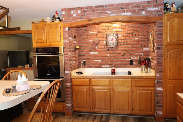 kitchen featuring black electric cooktop, double oven, and dark hardwood / wood-style flooring