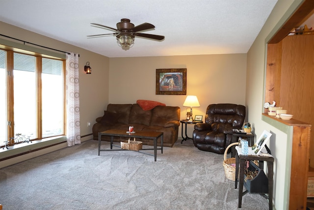 living room with a wealth of natural light, baseboard heating, carpet floors, and ceiling fan