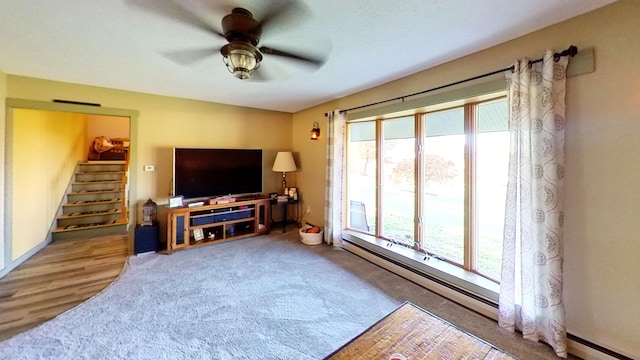 living room with ceiling fan, wood-type flooring, and baseboard heating