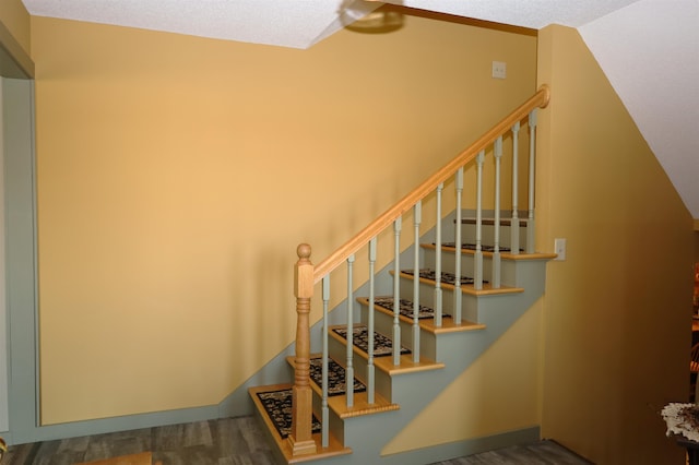 stairway featuring a textured ceiling and hardwood / wood-style floors