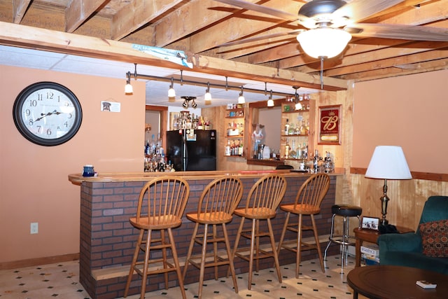 bar featuring ceiling fan and black fridge