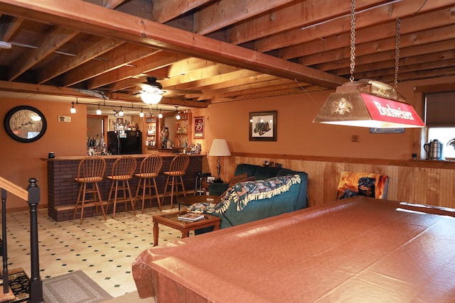 game room featuring pool table, wood walls, bar area, and ceiling fan