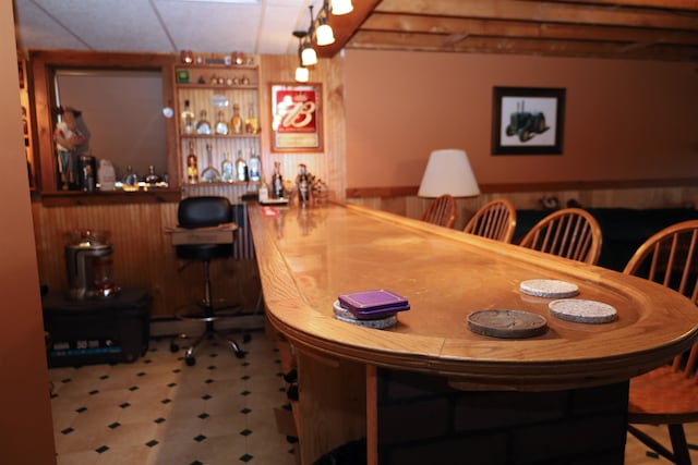 dining area with wooden walls and bar