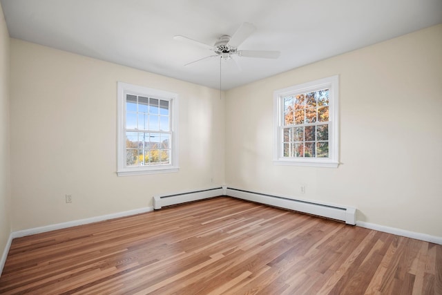 empty room with ceiling fan, a baseboard heating unit, and light wood-type flooring