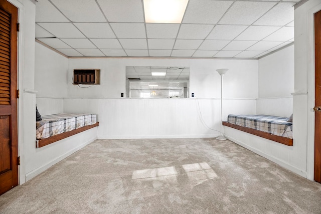 unfurnished bedroom featuring carpet floors and a paneled ceiling