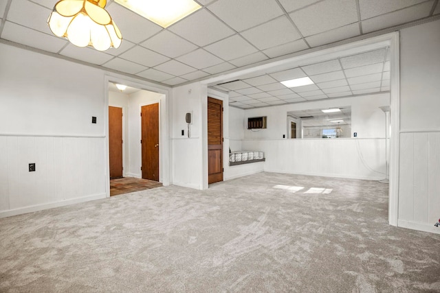 spare room featuring light carpet and a drop ceiling