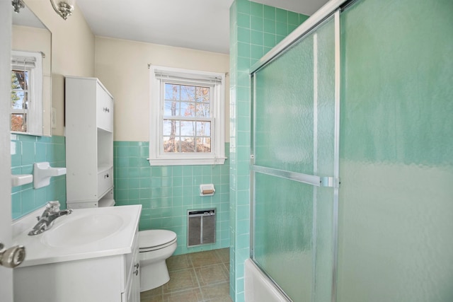 full bathroom featuring tile walls, vanity, bath / shower combo with glass door, and toilet