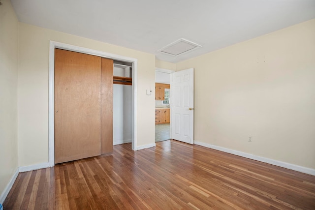 unfurnished bedroom featuring a closet and hardwood / wood-style flooring