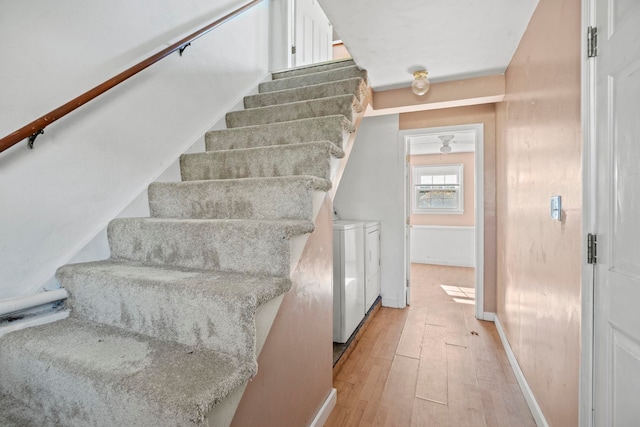 stairway with independent washer and dryer and hardwood / wood-style floors