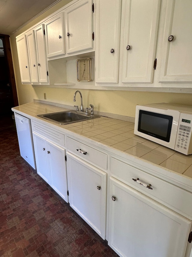 kitchen with white cabinets, white appliances, and sink