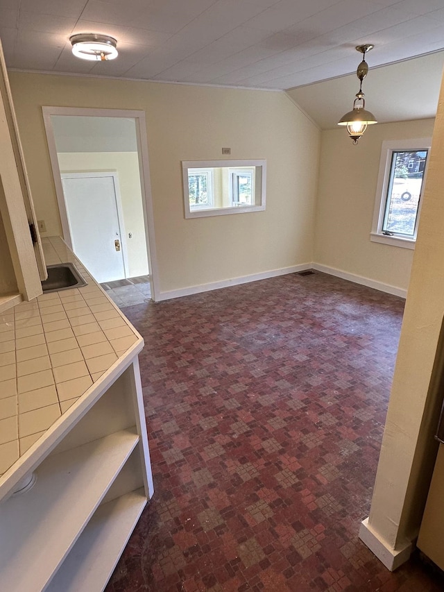 unfurnished room featuring sink and vaulted ceiling