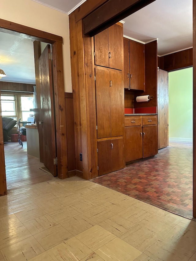 corridor with wooden walls and crown molding