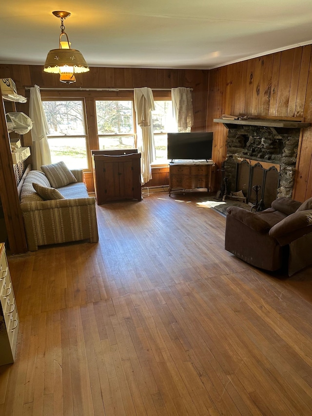 living room featuring a stone fireplace, wooden walls, and wood-type flooring