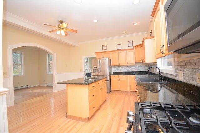 kitchen with a kitchen island with sink, light brown cabinets, stainless steel appliances, ornamental molding, and sink