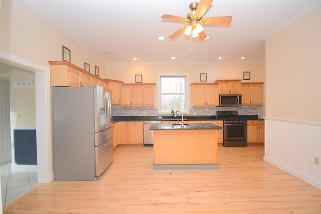 kitchen with appliances with stainless steel finishes, light brown cabinetry, light wood-type flooring, and an island with sink