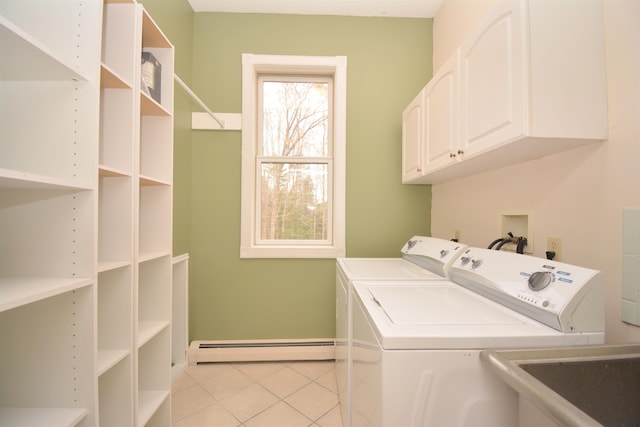 clothes washing area featuring a baseboard heating unit, sink, light tile patterned flooring, cabinets, and washing machine and dryer