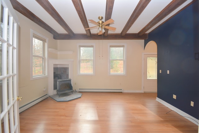 unfurnished living room with light hardwood / wood-style floors, a wood stove, and a baseboard radiator