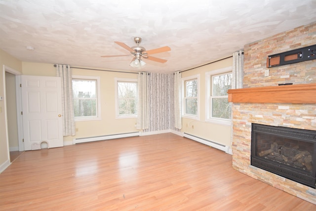 unfurnished living room featuring a baseboard heating unit, light hardwood / wood-style flooring, and ceiling fan