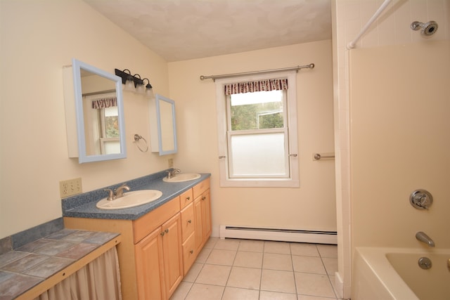 bathroom featuring vanity, tile patterned floors, a baseboard heating unit, and tiled shower / bath